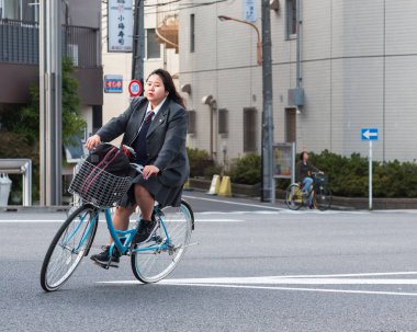 Tokyo, Japonya - 31 Ekim 2017: Tam kız bir bisiklet ile gidiyor. Metin için yer kopyalayın