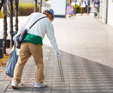Tokyo, Japonya - 7 Kasım 2017: Bir adam bir şehir sokak çöp toplar. Metin için yer kopyalayın                   