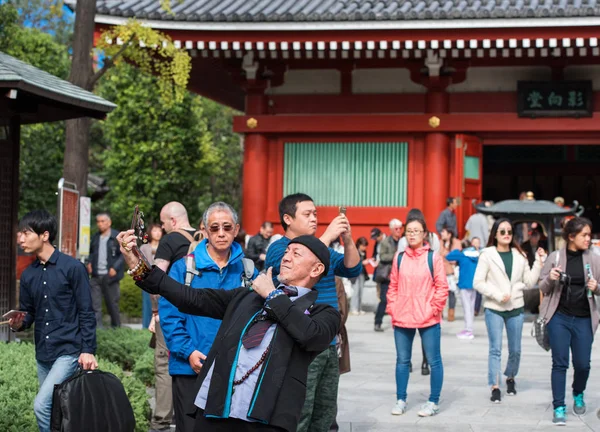 Tokyo, Japonya - 7 Kasım 2017: Şık bir adam selfie bir kalabalık arka planda yapar