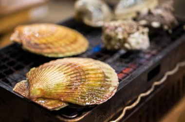 Yumuşakçalar yanıyor, Tokyo, Japonya bir kafede pişirilir. Yakın çekim