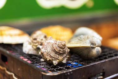 Yumuşakçalar yanıyor, Tokyo, Japonya bir kafede pişirilir. Yakın çekim