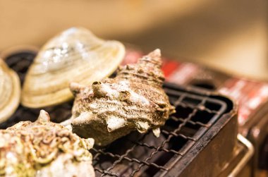 Yumuşakçalar yanıyor, Tokyo, Japonya bir kafede pişirilir. Yakın çekim