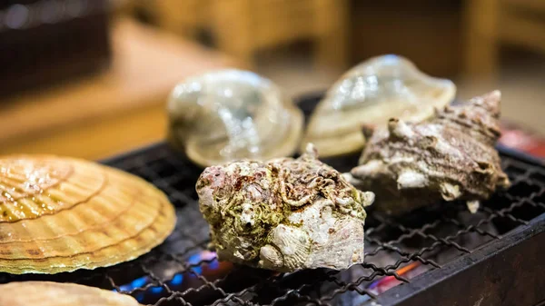 Yumuşakçalar yanıyor, Tokyo, Japonya bir kafede pişirilir. Yakın çekim