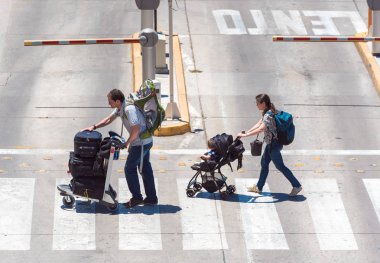 Santiago, Şili - 10 Ocak 2018: Bagajı olan aile havaalanında yolun karşısına geçiyor. Metin için alan kopyalama.   