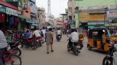 PUTTAPARTHI, ANDHRA PRADESH, INDIA - 10 Temmuz 2019: Puttaparthi 'de bir caddenin manzarası Rickshaw, Scooter, yolda yürüyen insanlar
