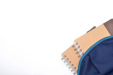 Okul çantasıyla düz uzanma görüntüsü ve beyaz arkaplanda yazı için alanı olan kırtasiye malzemesi. Seçici odak.