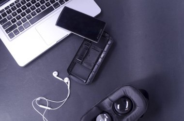 Akıllı telefonlu sanal gerçeklik gözlükleri, siyah arka planda laptop. Seçici odak.