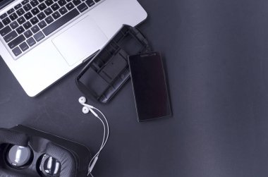 Akıllı telefonlu sanal gerçeklik gözlükleri, siyah arka planda laptop. Seçici odak.