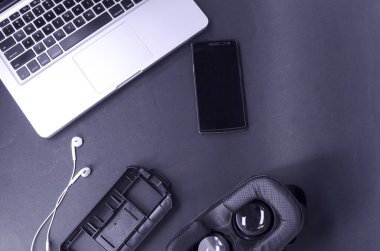 Akıllı telefonlu sanal gerçeklik gözlükleri, siyah arka planda laptop. Seçici odak.