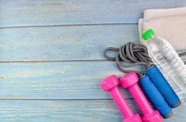 Dambılların, havlunun, suyun ve mavi ahşap zemin üzerinde fotokopi alanı olan halatın üst veya düz görünümü. Sağlıklı bir kavram. Seçici odak.