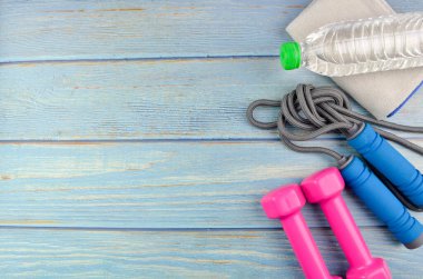 Dambılların, havlunun, suyun ve mavi ahşap zemin üzerinde fotokopi alanı olan halatın üst veya düz görünümü. Sağlıklı bir kavram. Seçici odak.