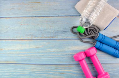 Dambılların, havlunun, suyun ve mavi ahşap zemin üzerinde fotokopi alanı olan halatın üst veya düz görünümü. Sağlıklı bir kavram. Seçici odak.