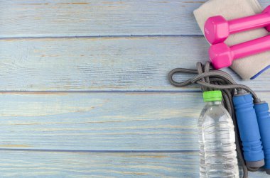 Dambılların, havlunun, suyun ve mavi ahşap zemin üzerinde fotokopi alanı olan halatın üst veya düz görünümü. Sağlıklı bir kavram. Seçici odak.