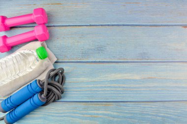 Dambılların, havlunun, suyun ve mavi ahşap zemin üzerinde fotokopi alanı olan halatın üst veya düz görünümü. Sağlıklı bir kavram. Seçici odak.