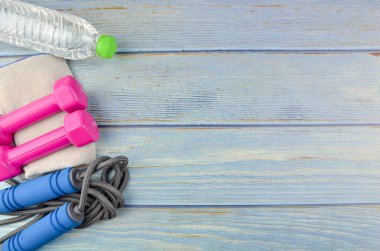 Dambılların, havlunun, suyun ve mavi ahşap zemin üzerinde fotokopi alanı olan halatın üst veya düz görünümü. Sağlıklı bir kavram. Seçici odak.