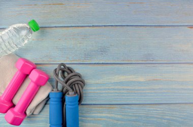 Dambılların, havlunun, suyun ve mavi ahşap zemin üzerinde fotokopi alanı olan halatın üst veya düz görünümü. Sağlıklı bir kavram. Seçici odak.