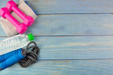 Dambılların, havlunun, suyun ve mavi ahşap zemin üzerinde fotokopi alanı olan halatın üst veya düz görünümü. Sağlıklı bir kavram. Seçici odak.