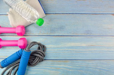 Dambılların, havlunun, suyun ve mavi ahşap zemin üzerinde fotokopi alanı olan halatın üst veya düz görünümü. Sağlıklı bir kavram. Seçici odak.