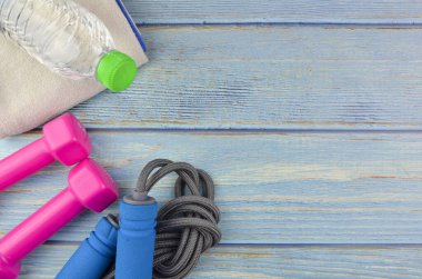 Dambılların, havlunun, suyun ve mavi ahşap zemin üzerinde fotokopi alanı olan halatın üst veya düz görünümü. Sağlıklı bir kavram. Seçici odak.