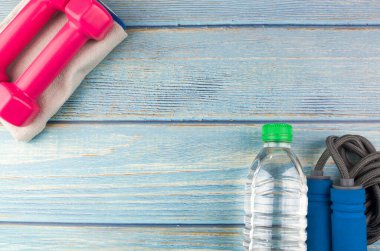 Dambılların, havlunun, suyun ve mavi ahşap zemin üzerinde fotokopi alanı olan halatın üst veya düz görünümü. Sağlıklı bir kavram. Seçici odak.