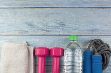 Dambılların, havlunun, suyun ve mavi ahşap zemin üzerinde fotokopi alanı olan halatın üst veya düz görünümü. Sağlıklı bir kavram. Seçici odak.