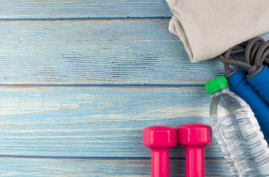 Dambılların, havlunun, suyun ve mavi ahşap zemin üzerinde fotokopi alanı olan halatın üst veya düz görünümü. Sağlıklı bir kavram. Seçici odak.