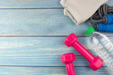 Dambılların, havlunun, suyun ve mavi ahşap zemin üzerinde fotokopi alanı olan halatın üst veya düz görünümü. Sağlıklı bir kavram. Seçici odak.