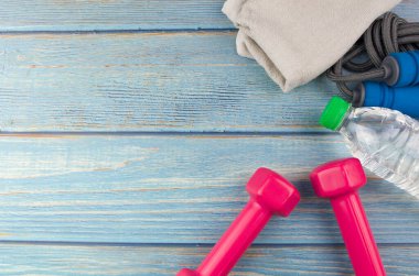 Dambılların, havlunun, suyun ve mavi ahşap zemin üzerinde fotokopi alanı olan halatın üst veya düz görünümü. Sağlıklı bir kavram. Seçici odak.