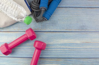 Dambılların, havlunun, suyun ve mavi ahşap zemin üzerinde fotokopi alanı olan halatın üst veya düz görünümü. Sağlıklı bir kavram. Seçici odak.