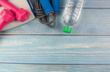 Dambılların, havlunun, suyun ve mavi ahşap zemin üzerinde fotokopi alanı olan halatın üst veya düz görünümü. Sağlıklı bir kavram. Seçici odak.