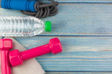 Dambılların, havlunun, suyun ve mavi ahşap zemin üzerinde fotokopi alanı olan halatın üst veya düz görünümü. Sağlıklı bir kavram. Seçici odak.