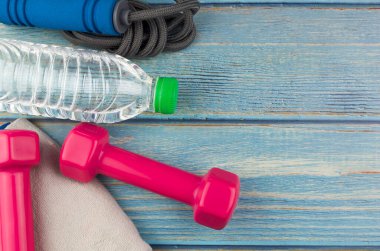 Dambılların, havlunun, suyun ve mavi ahşap zemin üzerinde fotokopi alanı olan halatın üst veya düz görünümü. Sağlıklı bir kavram. Seçici odak.