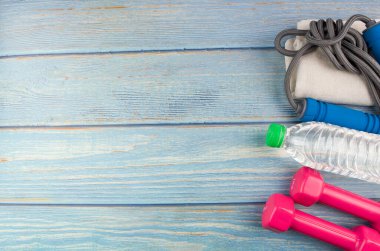 Dambılların, havlunun, suyun ve mavi ahşap zemin üzerinde fotokopi alanı olan halatın üst veya düz görünümü. Sağlıklı bir kavram. Seçici odak.