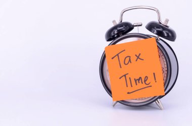 Alarm saati için vergi zamanı ve beyaz arka planda bozuk paralar. Seçici odak.