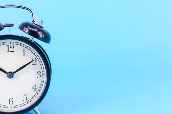 Alarm clock on blue background. Selective focus.