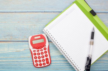 Bütçe kavramı. Tahta arka planda hesap makinesi, kalem ve defter. İş konsepti ve üst görünüm.