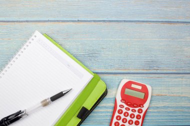 Bütçe kavramı. Tahta arka planda hesap makinesi, kalem ve defter. İş konsepti ve üst görünüm.
