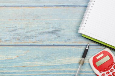 Bütçe kavramı. Tahta arka planda hesap makinesi, kalem ve defter. İş konsepti ve üst görünüm.