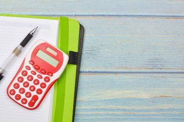 Bütçe kavramı. Tahta arka planda hesap makinesi, kalem ve defter. İş konsepti ve üst görünüm.