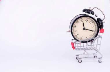 Alışveriş arabası ve beyaz arka planda klasik çalar saat. Satış zamanı alışveriş merkezi market tüketicisi konsepti satın al. Seçici odak.