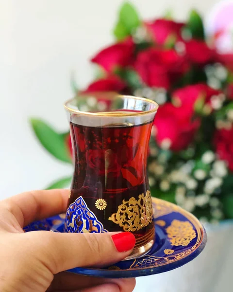 Geleneksel Türk çay, kırmızı gül arka plan fincan tutan kadın