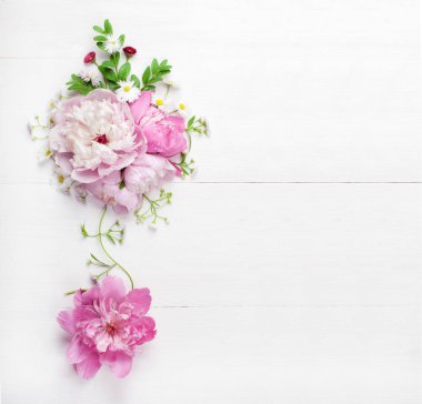Beyaz ahşap zemin üzerinde güzel pembe peonies buket. Üstten görünüm. Kopya alanı