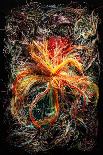 Colorful tangled threads on black background. Closeup.