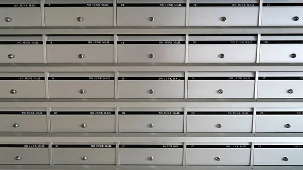 No junk mail, silver metal mailbox pattern with lockable center in apartment building.