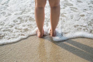 bir sahilde yalınayak kalan kadın