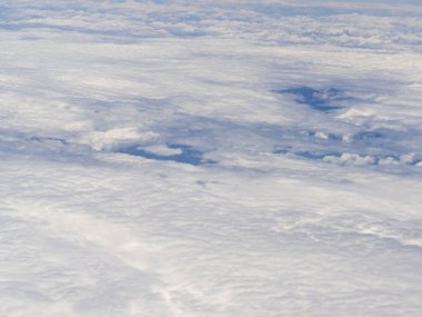 Beyaz bulutlar ve mavi gökyüzünün bir parçası üzerinde uçan