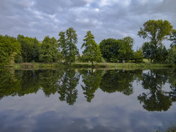 Nublado día de verano hermoso reflejo de la naturaleza en el lago surfac — Foto de Stock