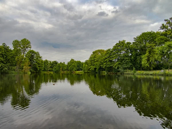 Bosque de Primavera de Europa y reflejo del cielo en la superficie del lago — Foto de Stock