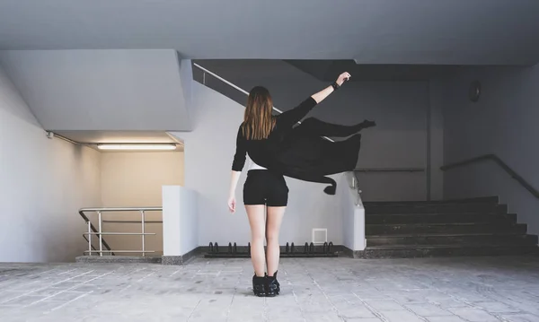 Одинокая девушка стоит спиной к камере на перекрестке подземки. Летающая ткань. Концепция одиночества в городе — стоковое фото