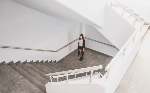 Красивая девушка стоит на лестнице с закрытыми глазами. Концепция одиночества в городе . — стоковое фото
